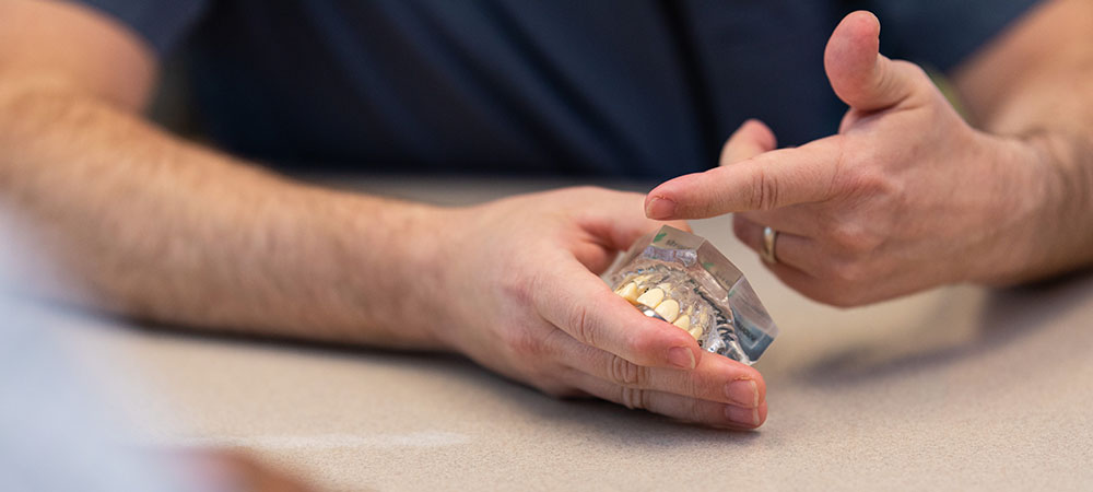 Dr. Ficca pointing at a model of teeth