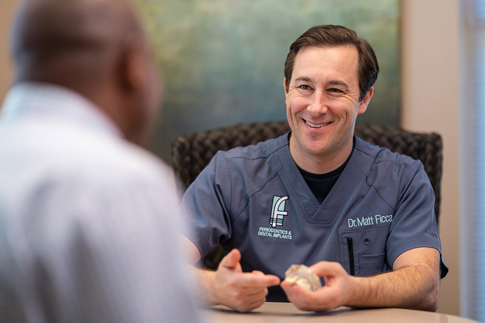 Dr. Ficca pointing to a model of teeth